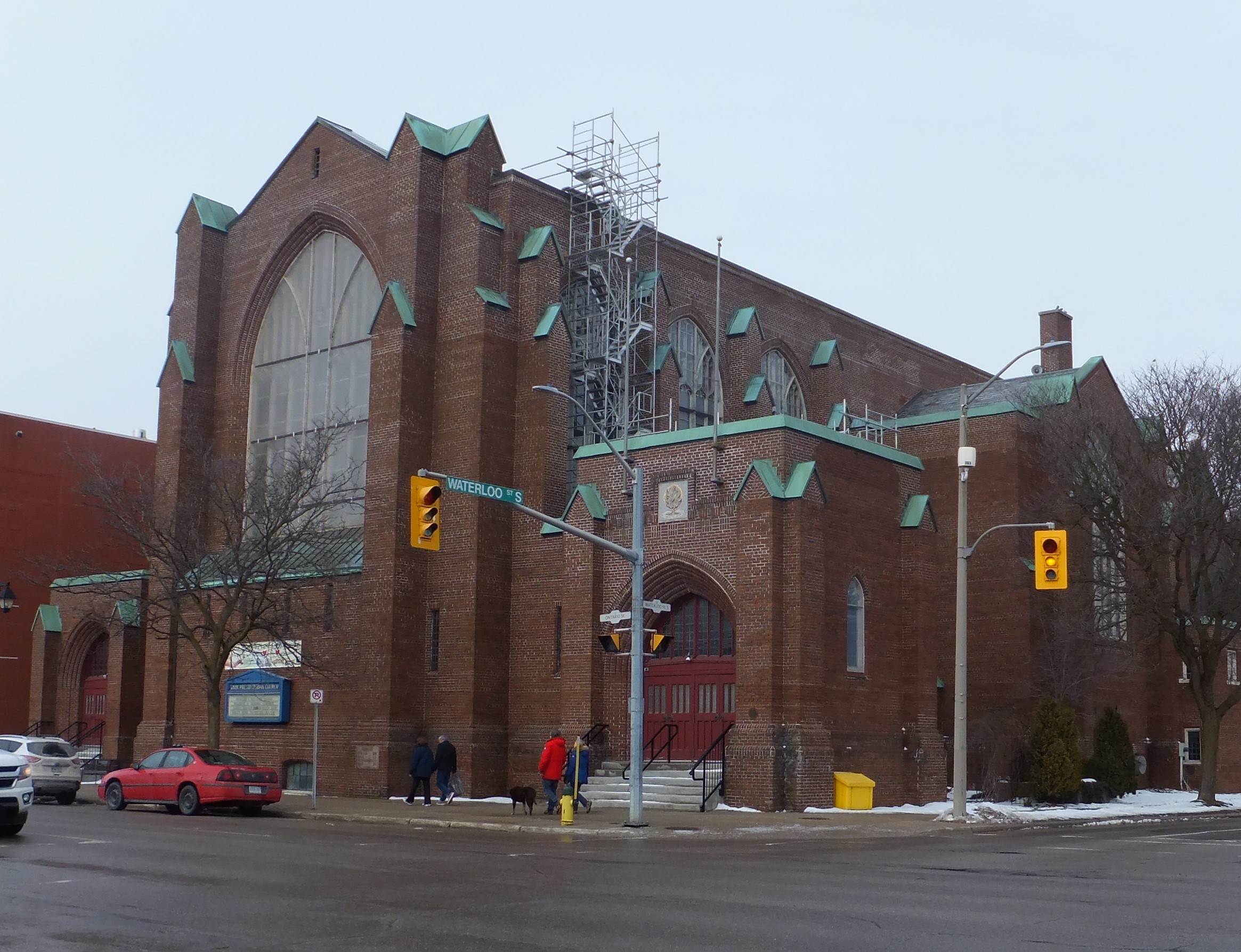 Reddish brown brick Gothic Revival style church with multi-paned large pointed window