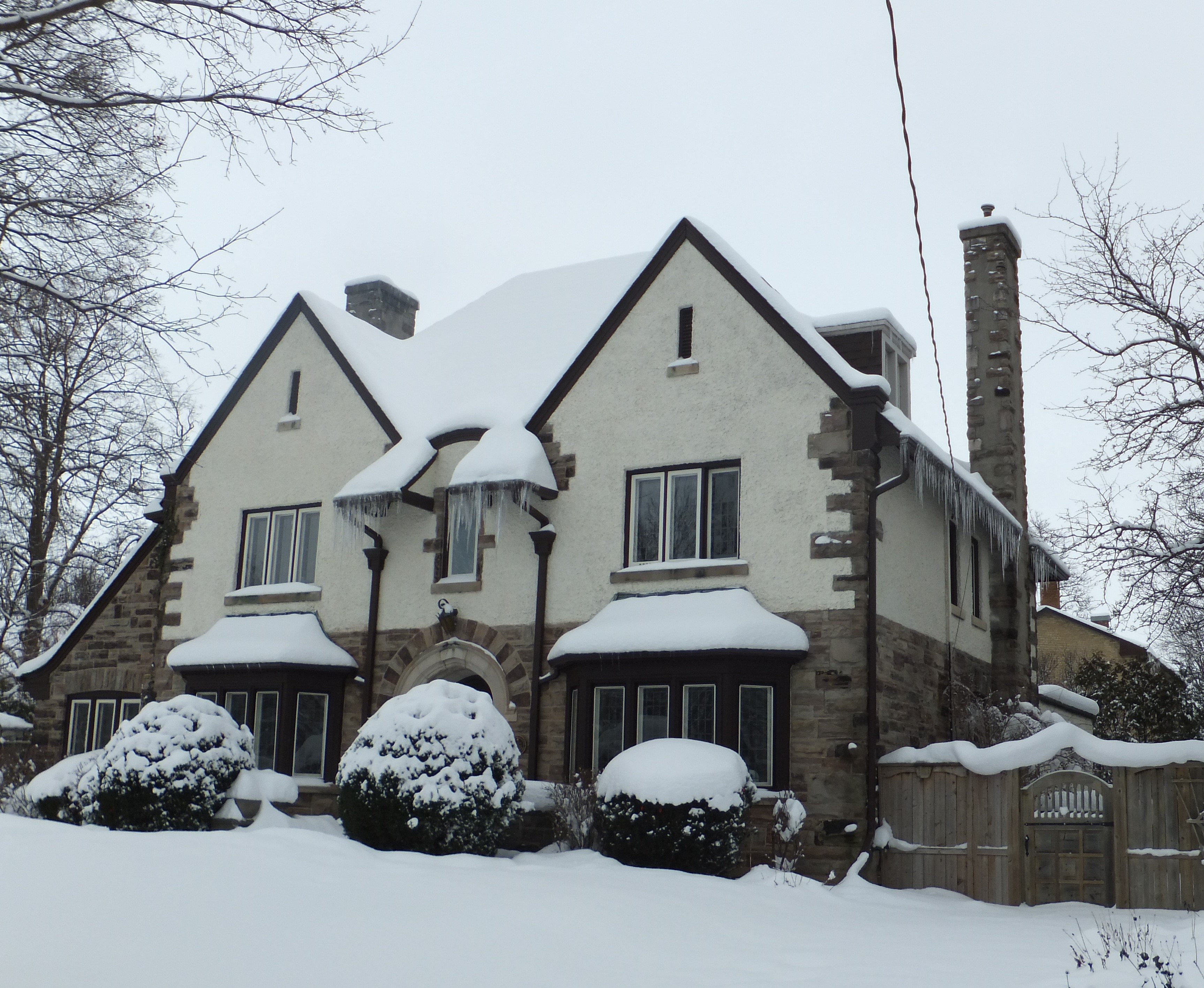 Grey and brown stone and stucco Jacobethean Revival style house