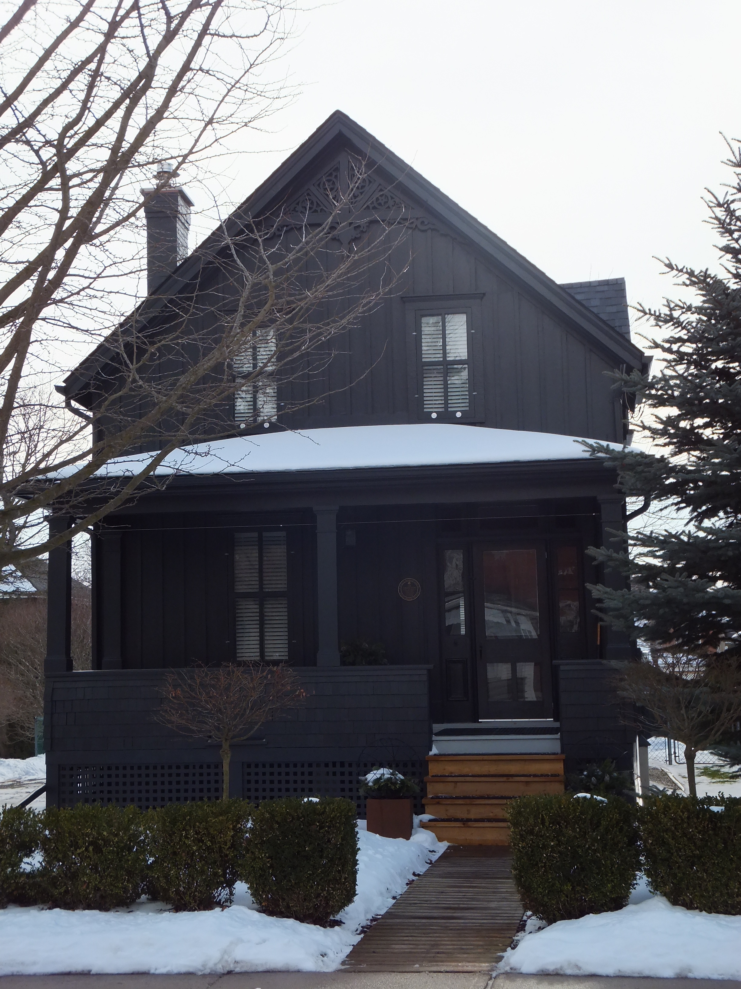 Dark grey painted board and batten Vernacular Gable style house