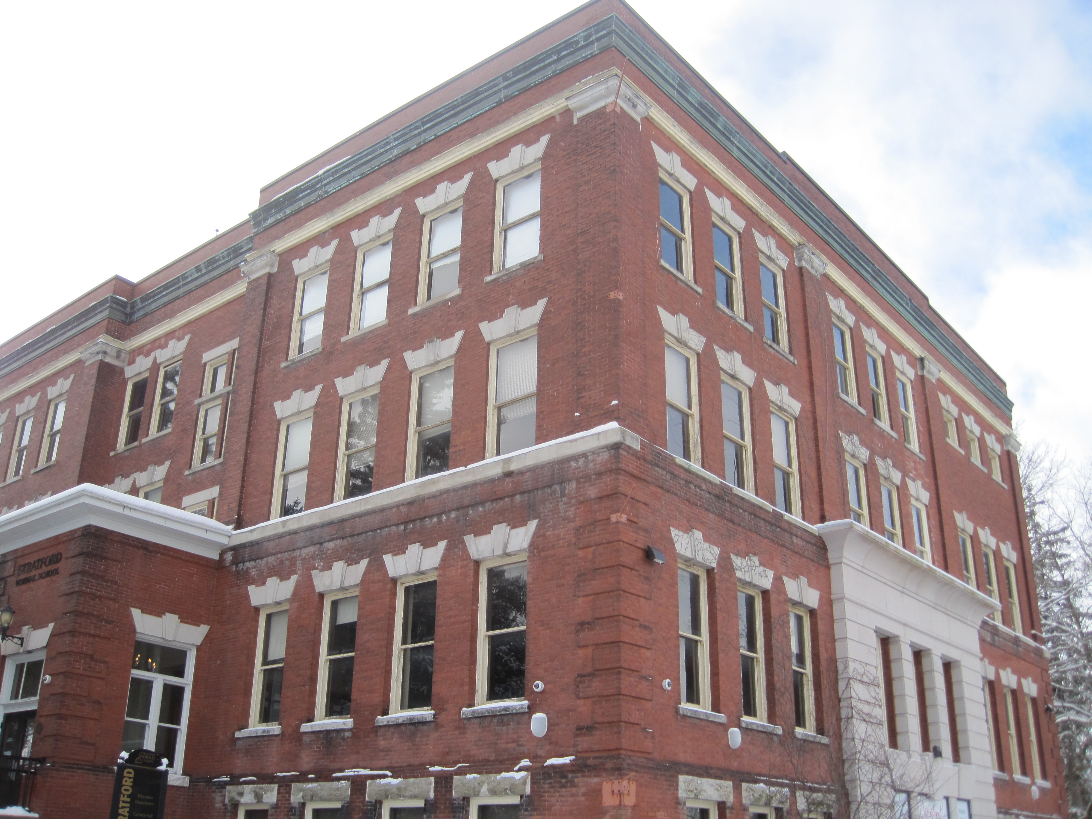 Three storey red brick Romanesque Revival style building