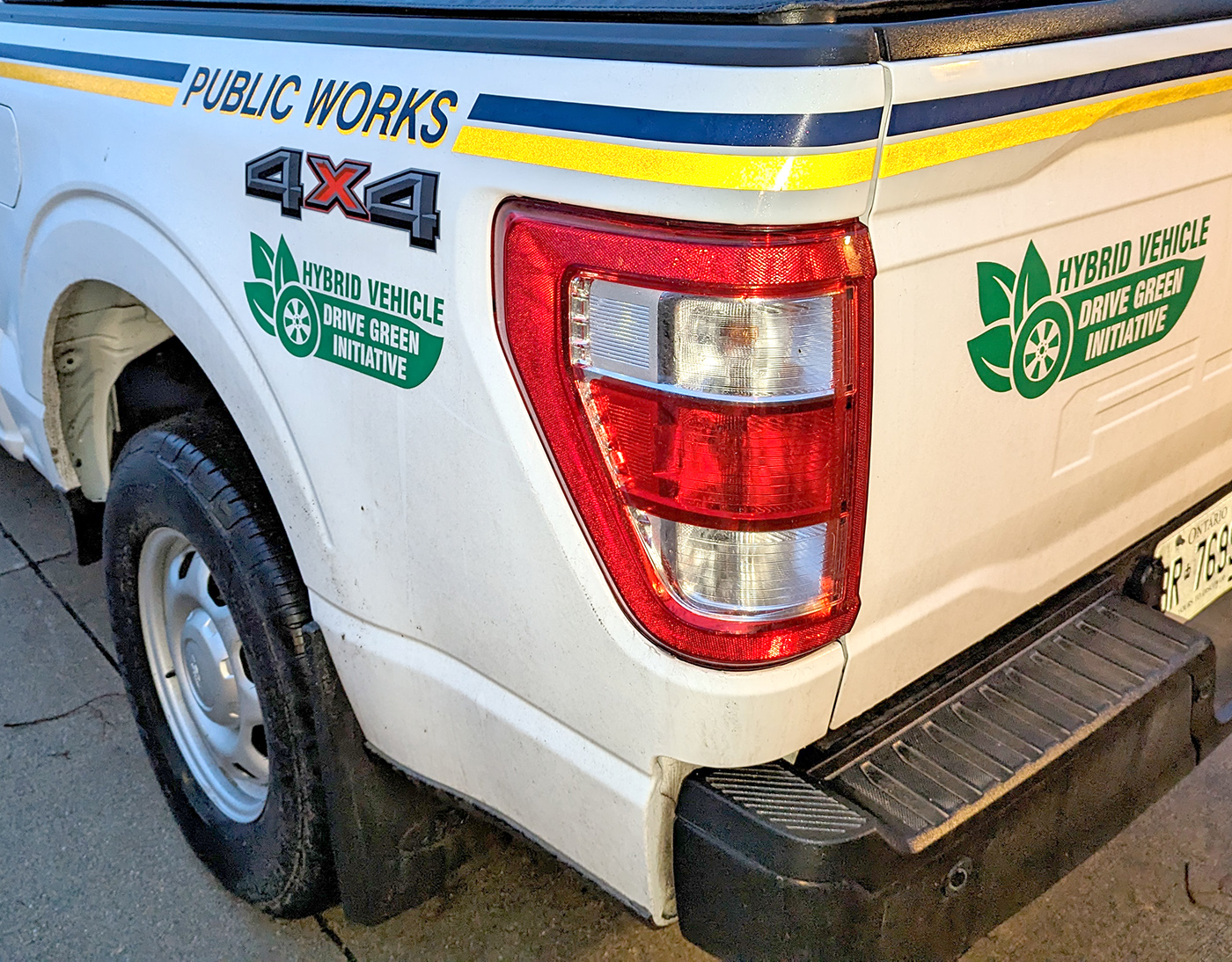 back of white pickup truck with Hybrid Vehicle sticker